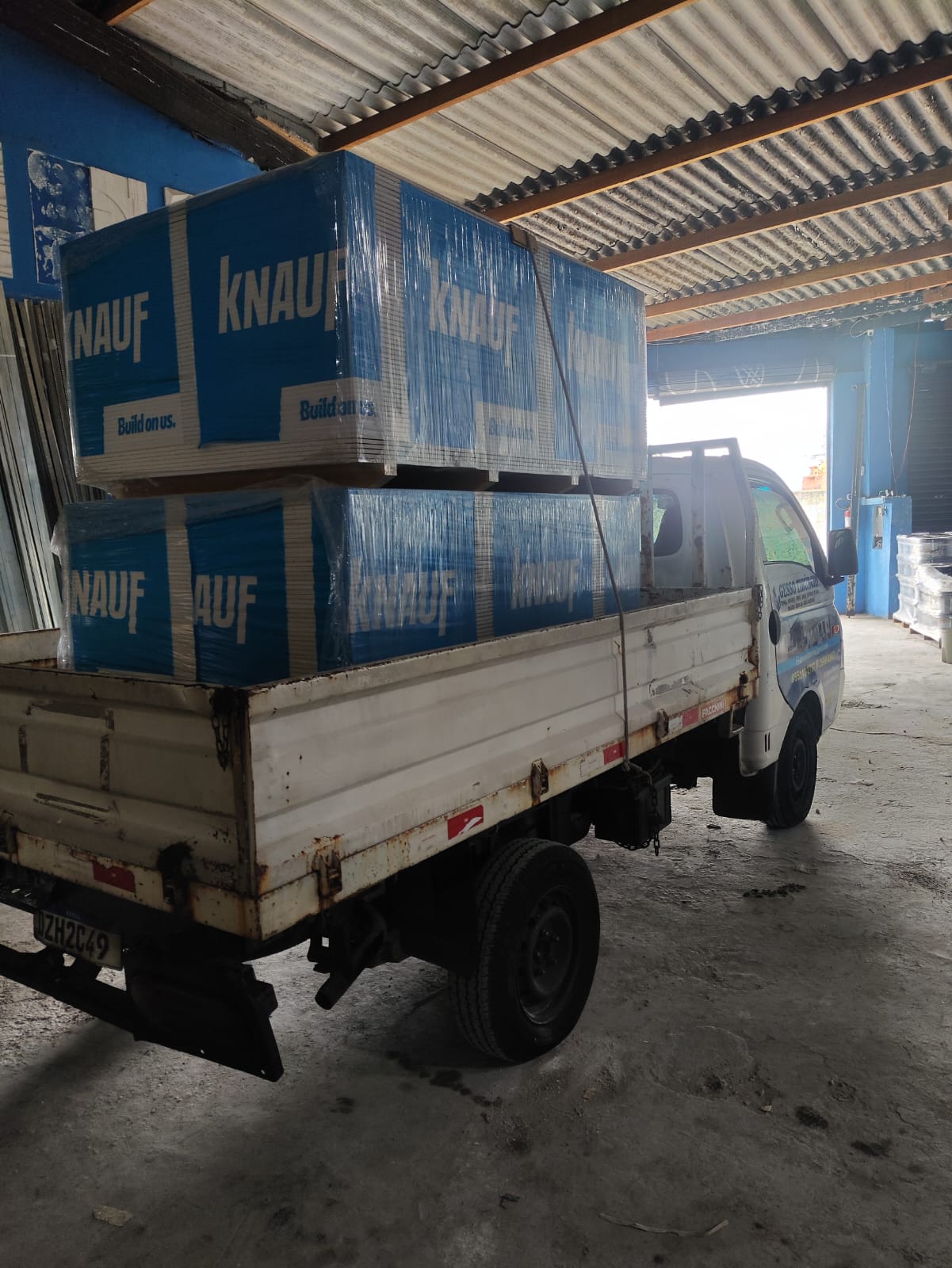Foto completa do caminhão da Gesso Recanto carregado com placas de drywall no estoque próprio